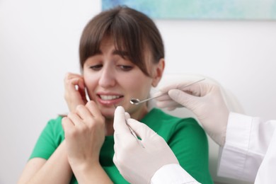 Photo of Scared woman having appointment with dentist in clinic