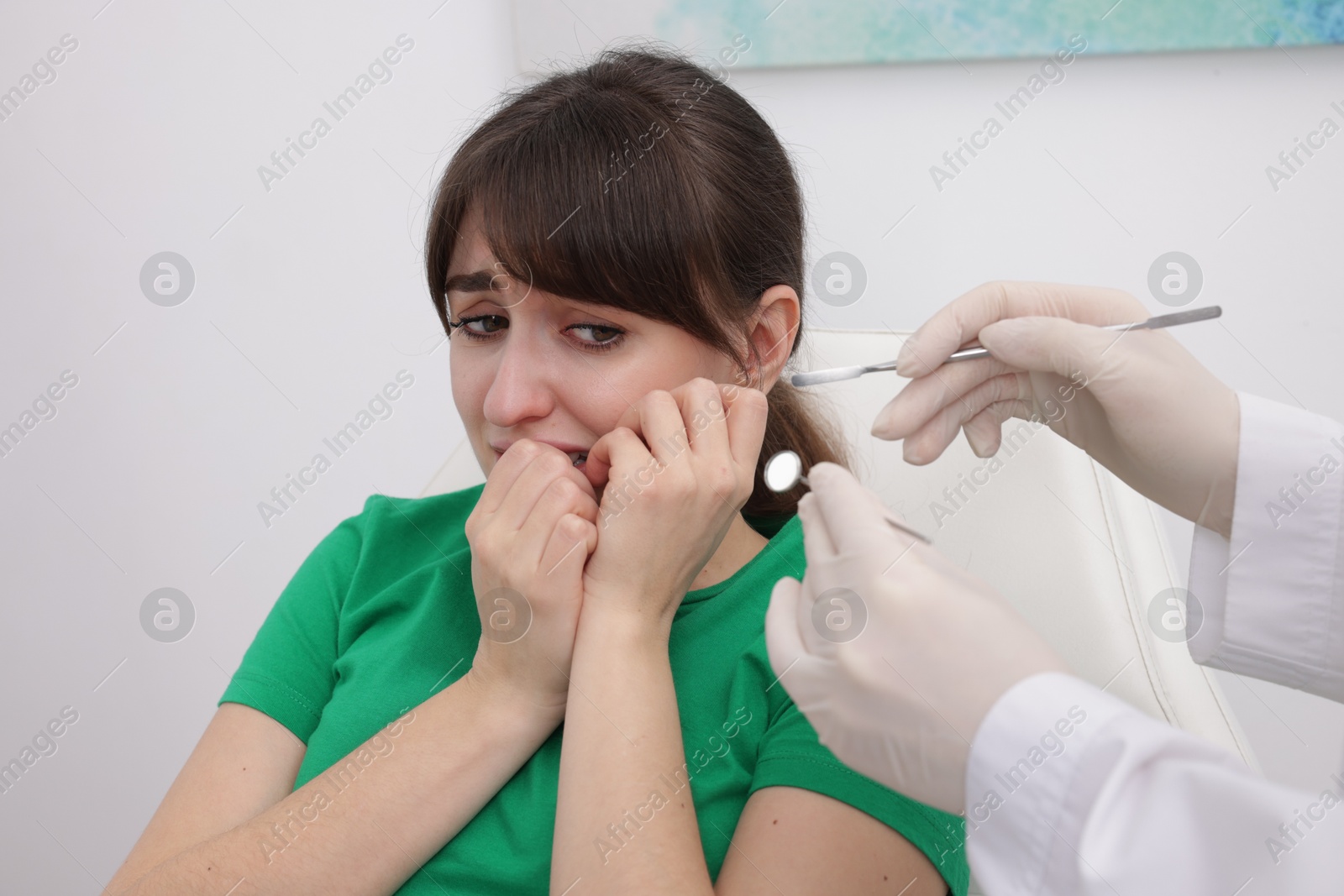 Photo of Scared woman having appointment with dentist in clinic