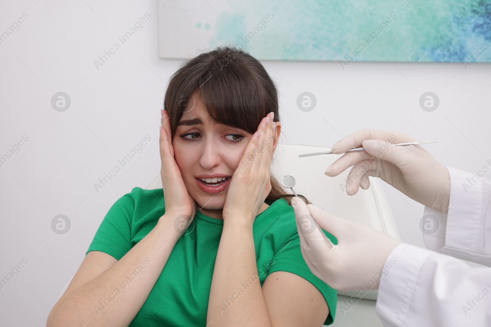 Photo of Scared woman having appointment with dentist in clinic