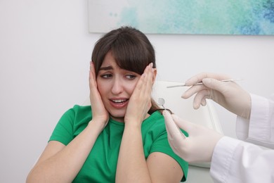 Scared woman having appointment with dentist in clinic