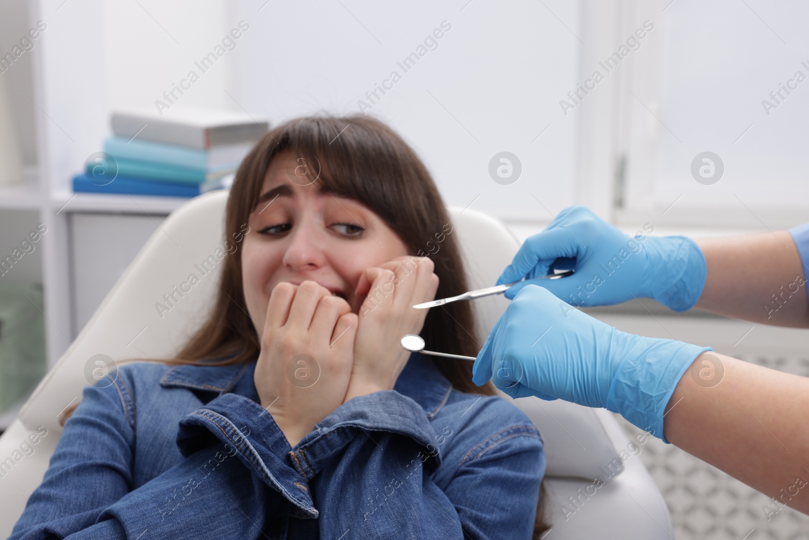 Photo of Scared woman having appointment with dentist in clinic