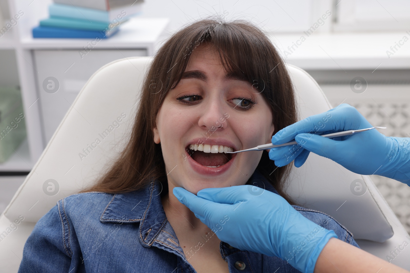 Photo of Scared woman having appointment with dentist in clinic