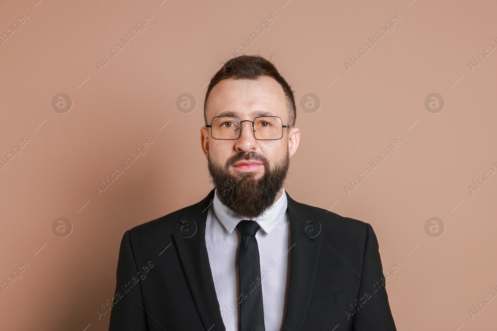 Photo of Handsome bearded man in suit on brown background