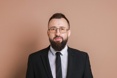 Handsome bearded man in suit on brown background