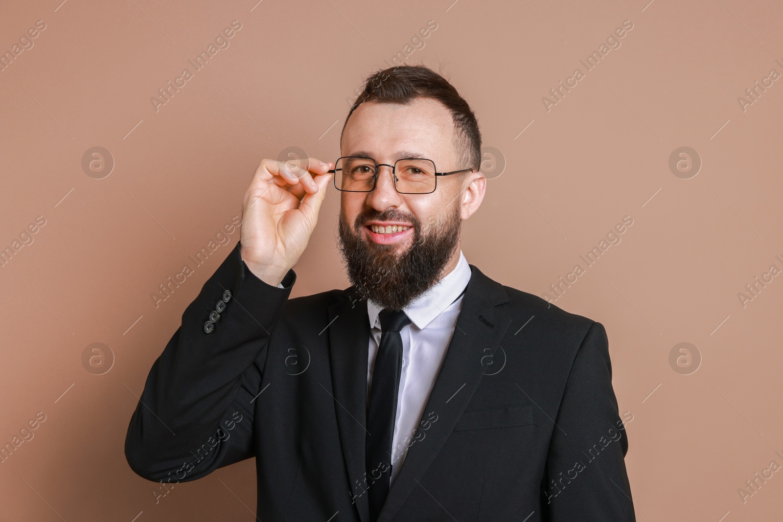 Photo of Handsome bearded man in suit on brown background