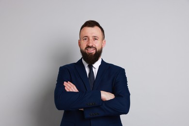 Handsome bearded man in suit on grey background