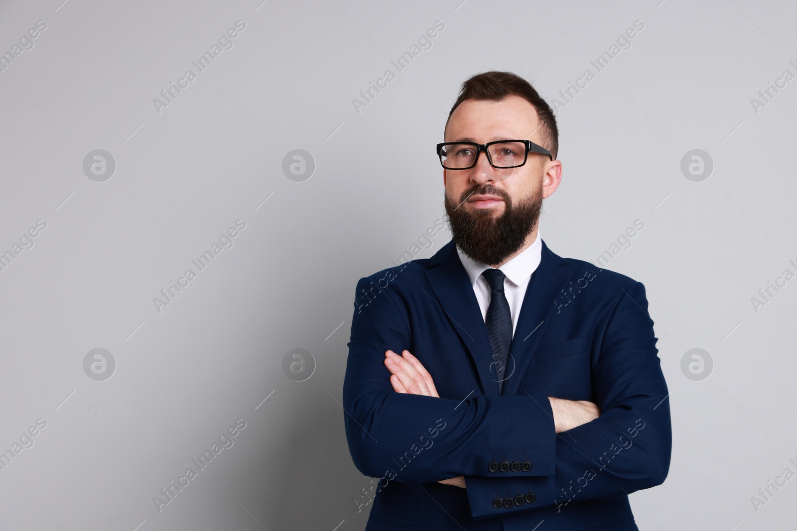 Photo of Handsome bearded man in suit on grey background. Space for text