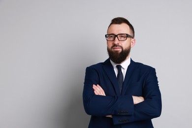 Handsome bearded man in suit on grey background. Space for text