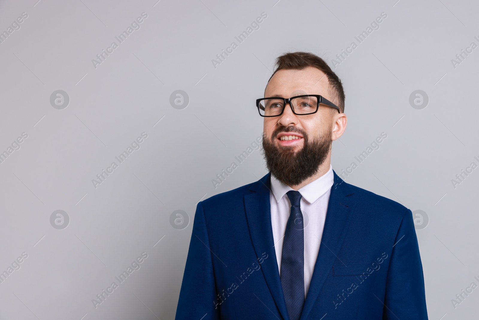 Photo of Handsome bearded man in suit on grey background. Space for text