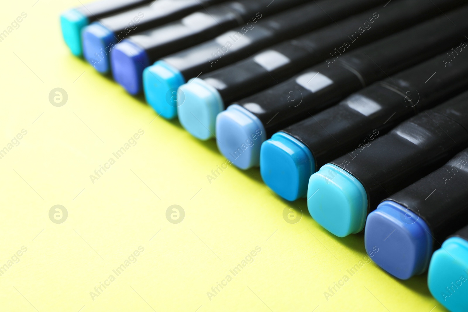 Photo of Color double sided markers on yellow background, closeup. Space for text