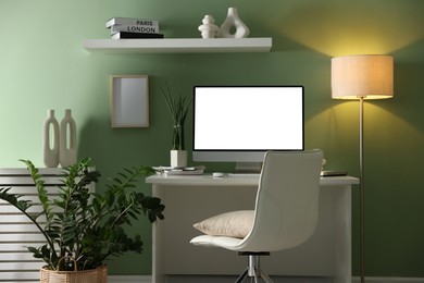 Image of Comfortable workplace at home. Computer monitor with blank white screen on desk in room