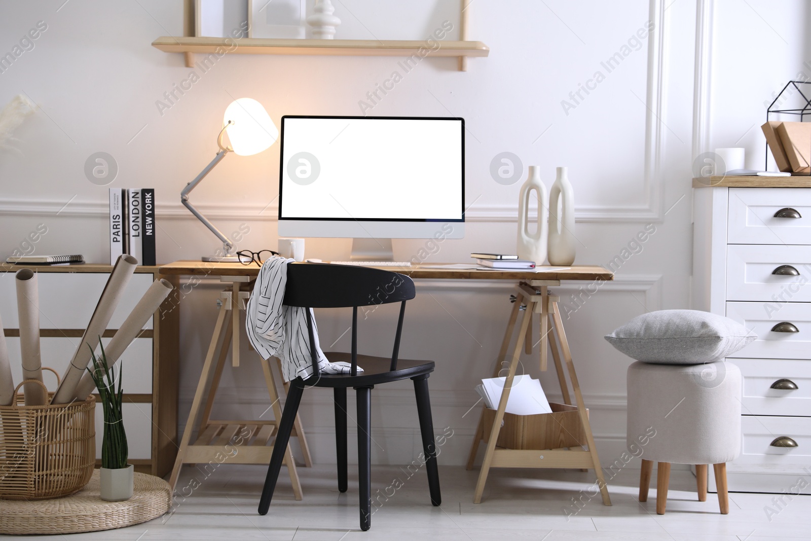 Image of Comfortable workplace at home. Computer monitor with blank white screen on desk in room