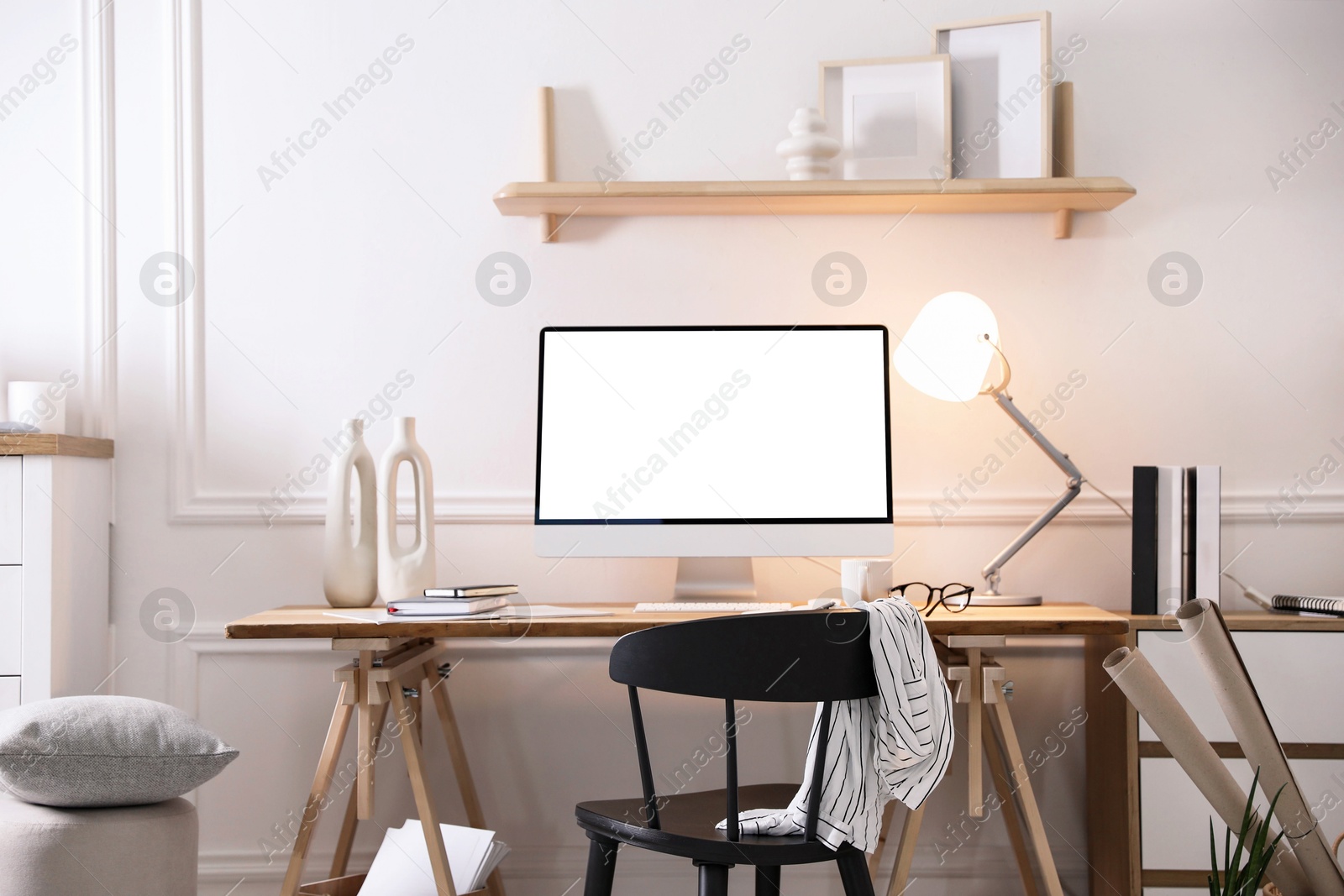 Image of Comfortable workplace at home. Computer monitor with blank white screen on desk in room