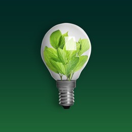 Image of Light bulb with fresh leaves inside on green background. Concepts of eco-friendly environment and saving energy