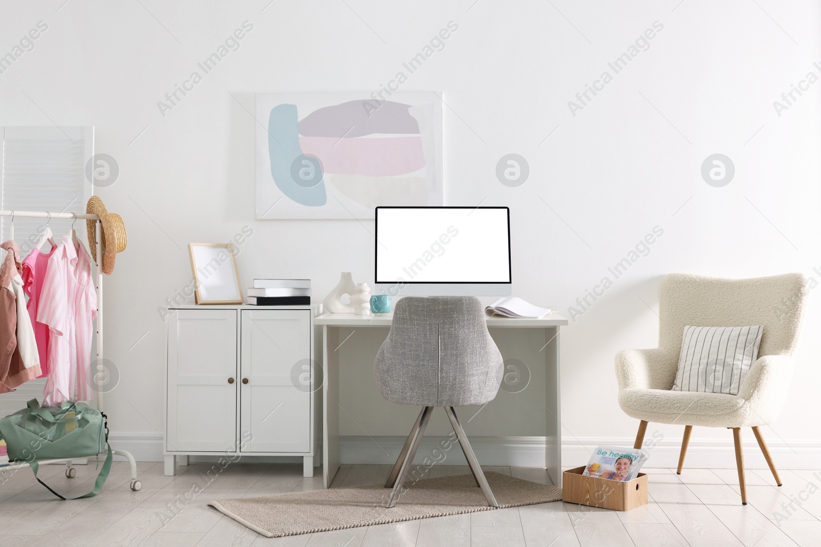 Image of Comfortable workplace at home. Computer monitor with blank white screen on desk in room