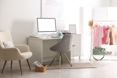 Image of Comfortable workplace at home. Computer monitor with blank white screen on desk in room