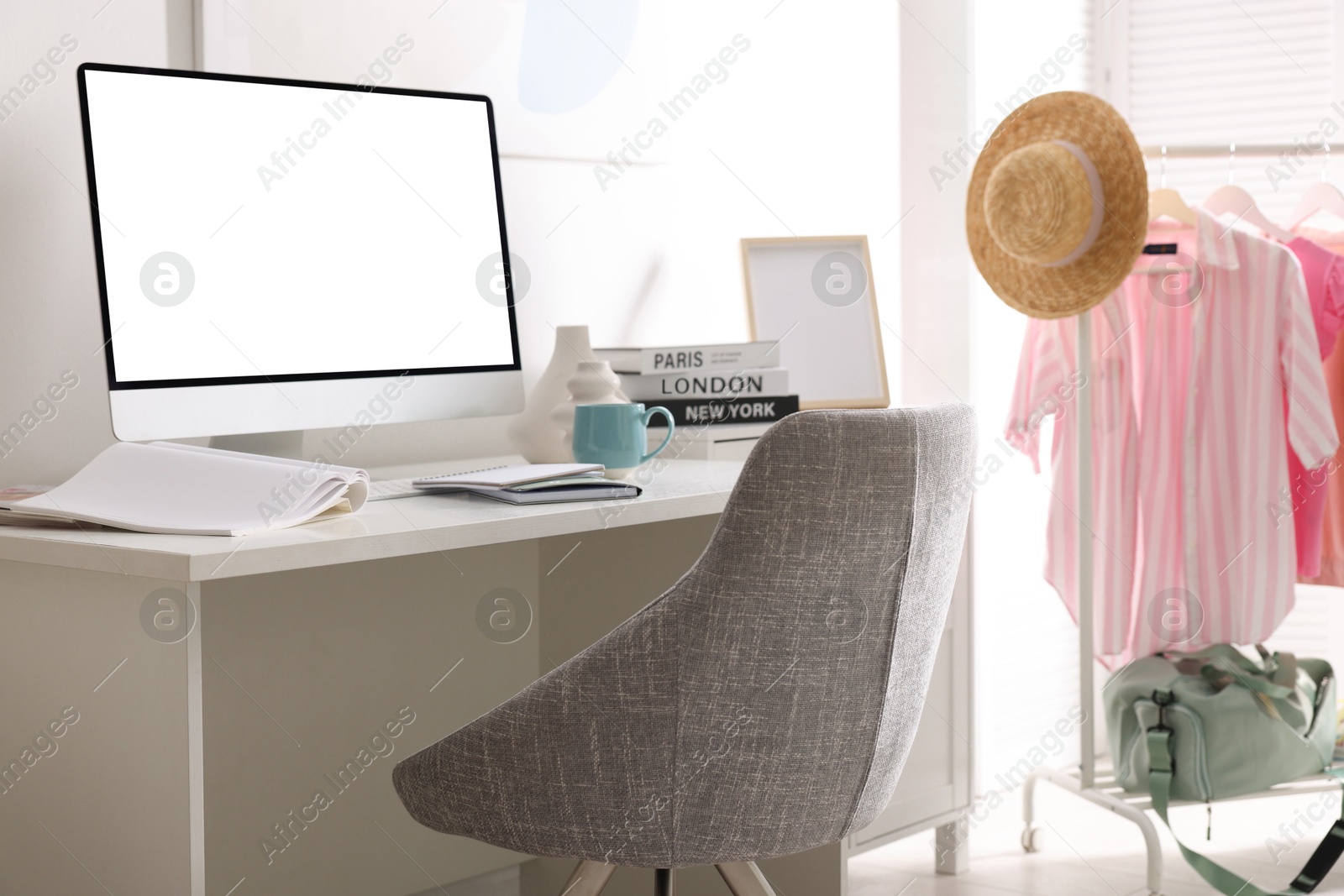 Image of Comfortable workplace at home. Computer monitor with blank white screen on desk in room