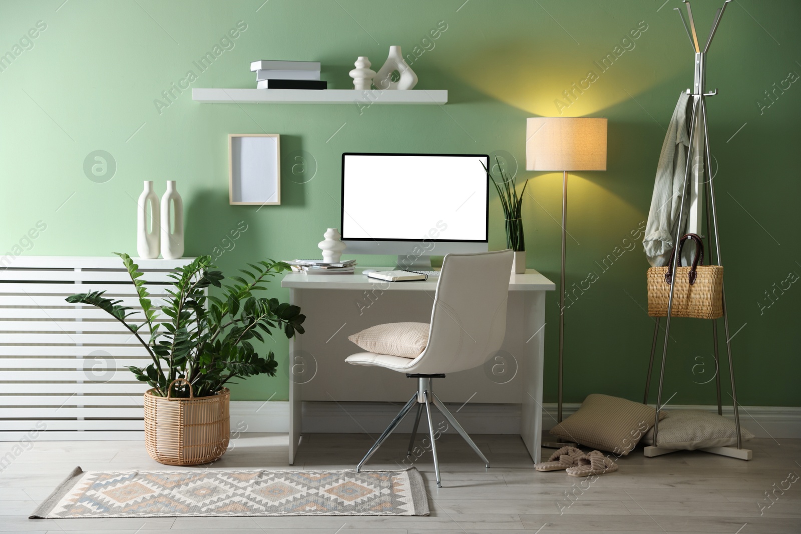 Image of Comfortable workplace at home. Computer monitor with blank white screen on desk in room