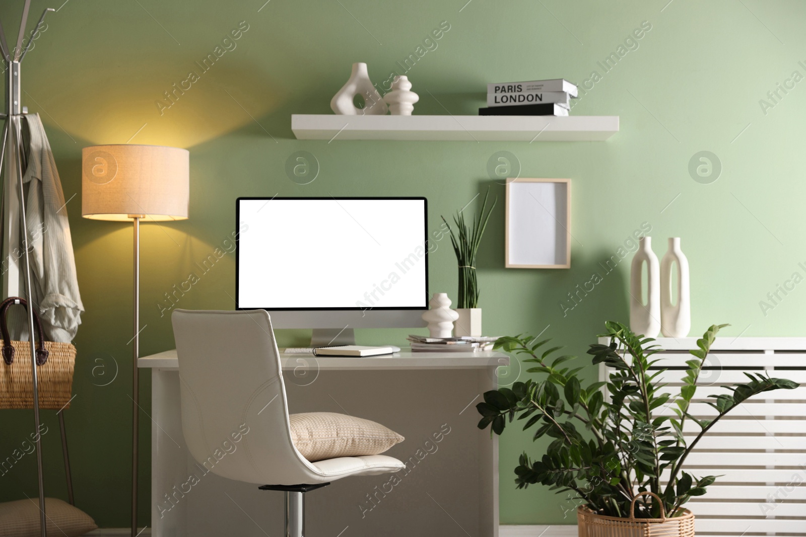 Image of Comfortable workplace at home. Computer monitor with blank white screen on desk in room