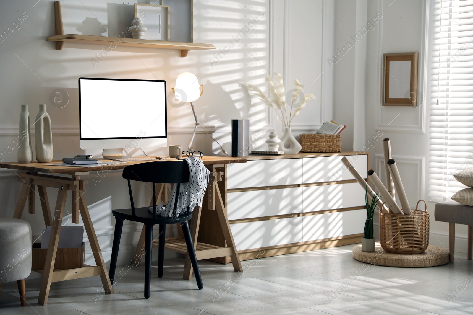 Image of Comfortable workplace at home. Computer monitor with blank white screen on desk in room