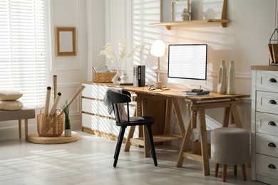 Image of Comfortable workplace at home. Computer monitor with blank white screen on desk in room