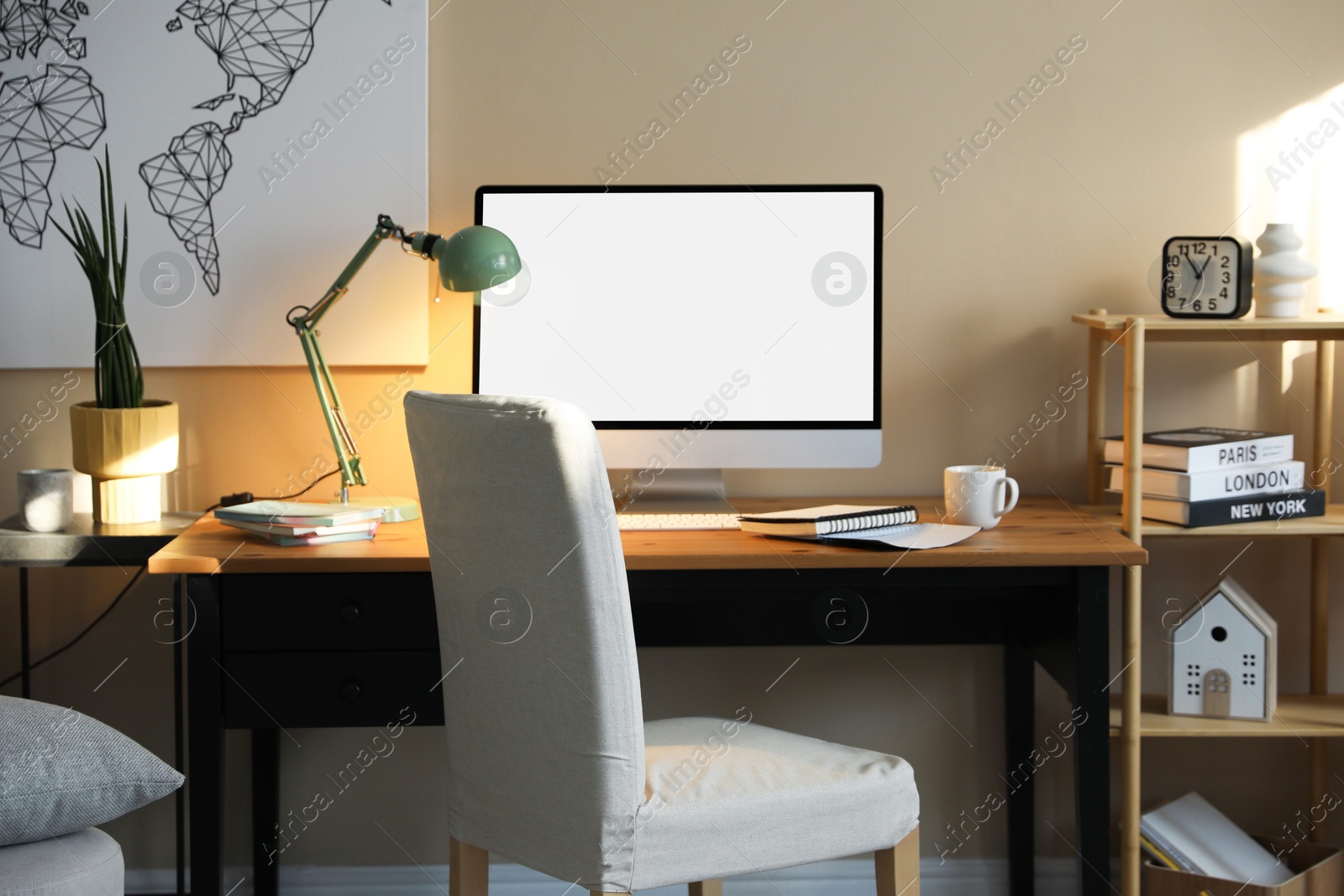 Image of Comfortable workplace at home. Computer monitor with blank white screen on desk in room