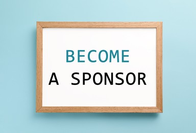 White board with text Become A Sponsor on turquoise background, top view