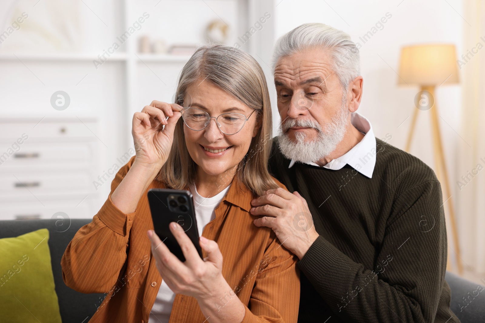 Photo of Cute elderly couple with smartphone at home