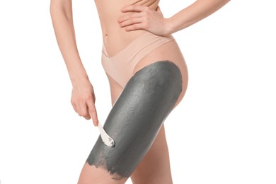 Photo of Woman applying cosmetic product for spa body wraps onto her leg against white background, closeup