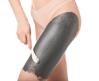 Photo of Woman applying cosmetic product for spa body wraps onto her leg against white background, closeup