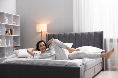 Photo of Young woman exercising on bed at home. Morning routine