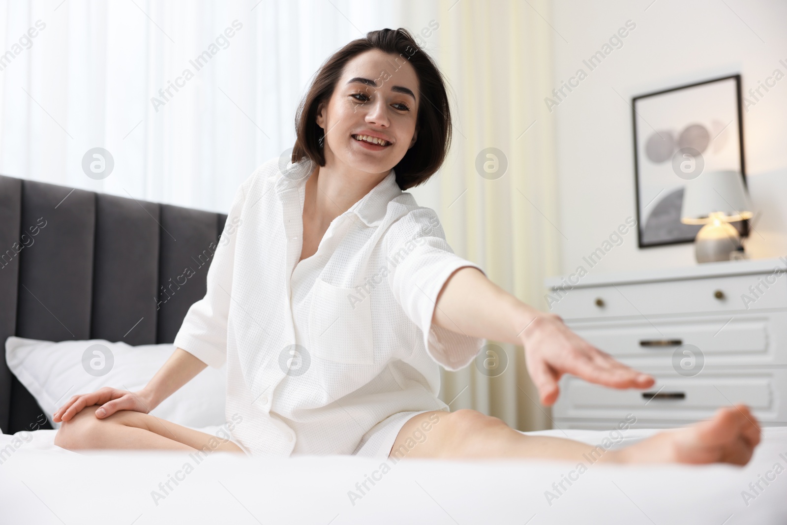 Photo of Young woman exercising on bed at home. Morning routine