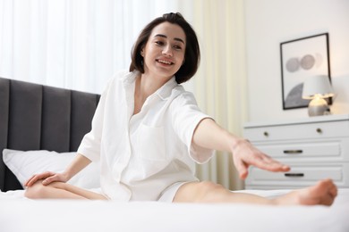 Young woman exercising on bed at home. Morning routine