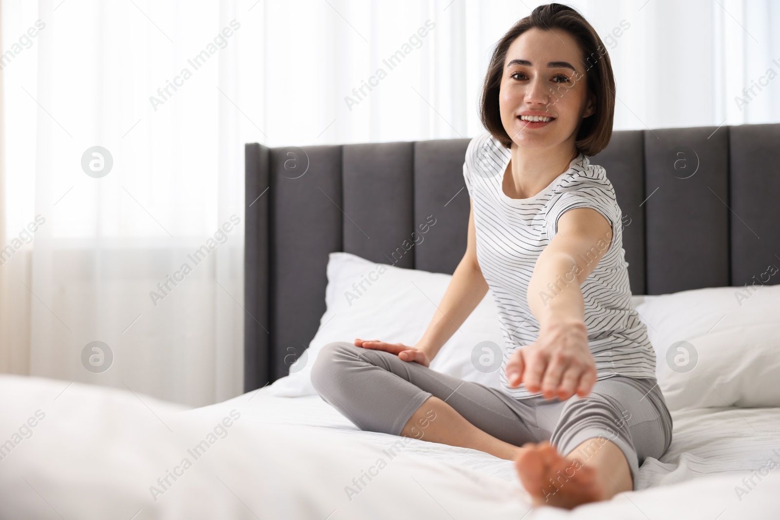 Photo of Young woman exercising on bed at home. Morning routine