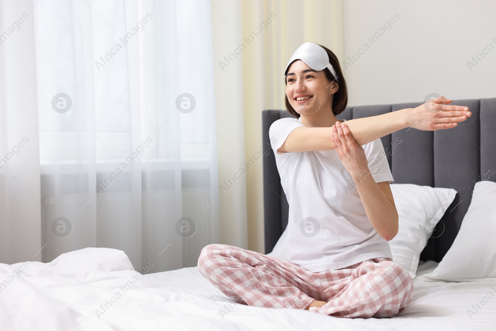 Photo of Young woman exercising on bed at home. Morning routine