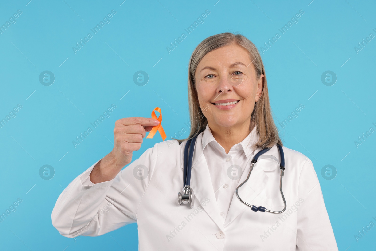 Photo of Multiple Sclerosis awareness. Doctor with orange ribbon on light blue background