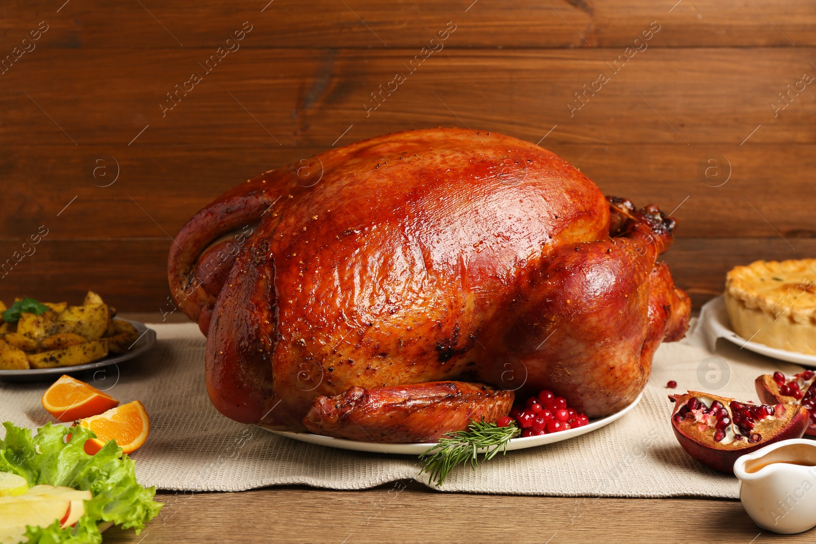 Photo of Whole baked turkey and other dishes served on wooden table