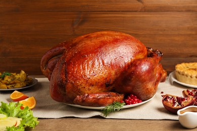 Photo of Whole baked turkey and other dishes served on wooden table