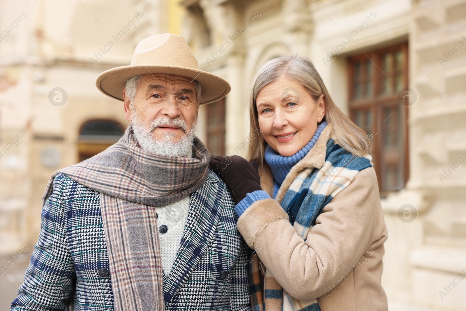 Photo of Family portrait of happy elderly couple on city street