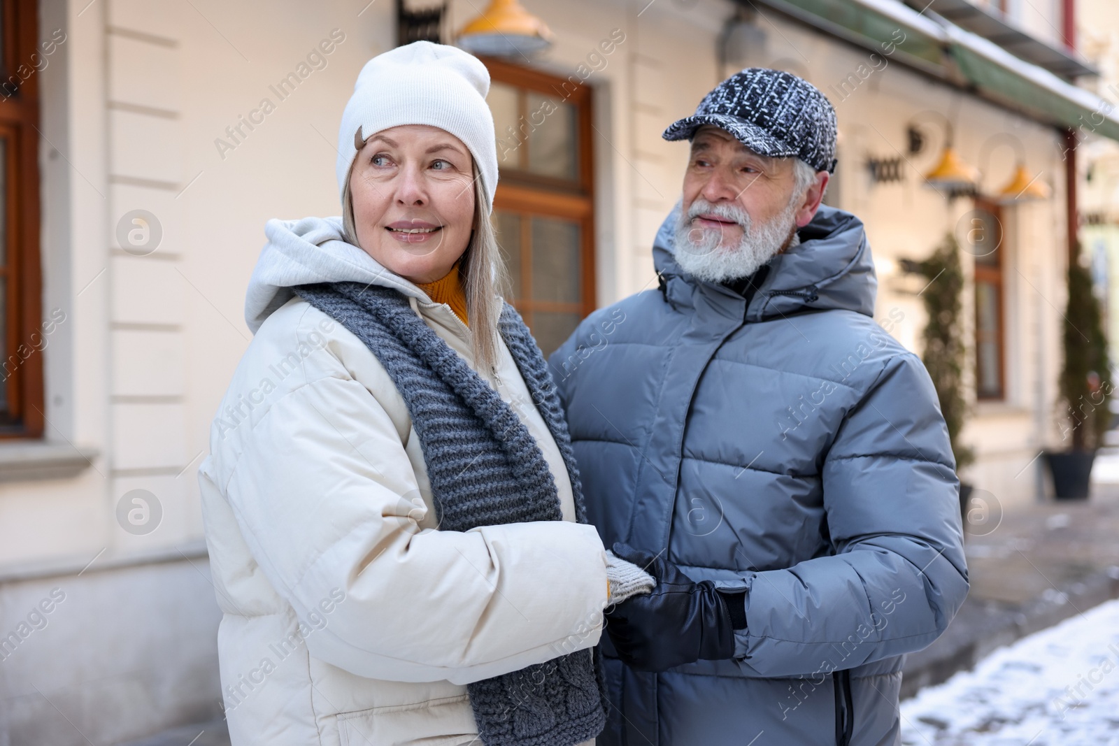 Photo of Happy elderly couple holding hands on city street