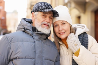 Photo of Family portrait of happy elderly couple on city street