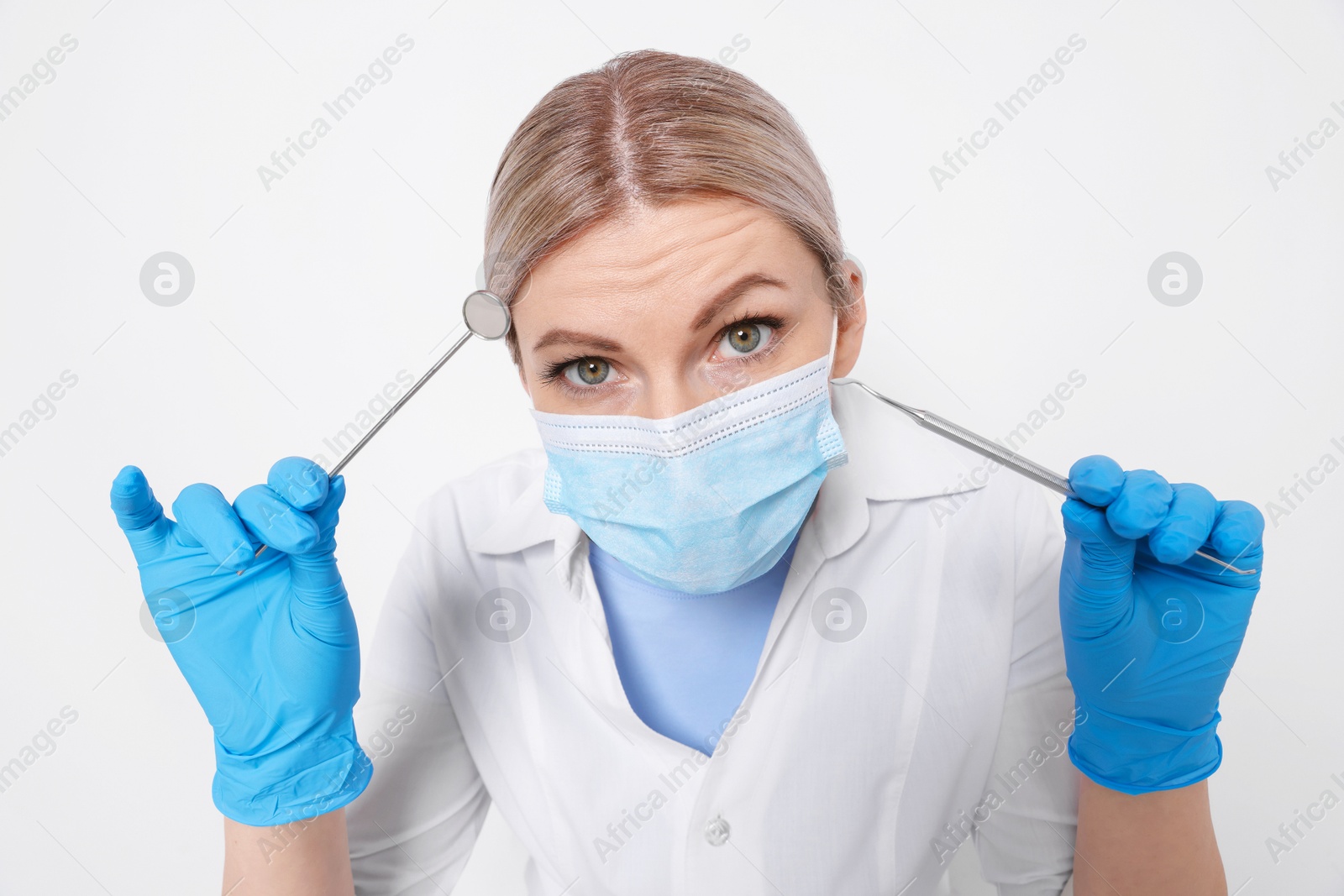 Photo of Professional dentist with tools on white background