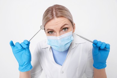 Professional dentist with tools on white background