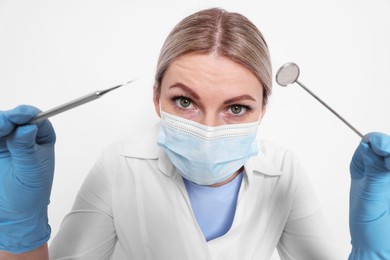 Photo of Professional dentist with tools on white background