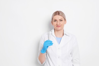 Professional dentist with tools on white background. Space for text