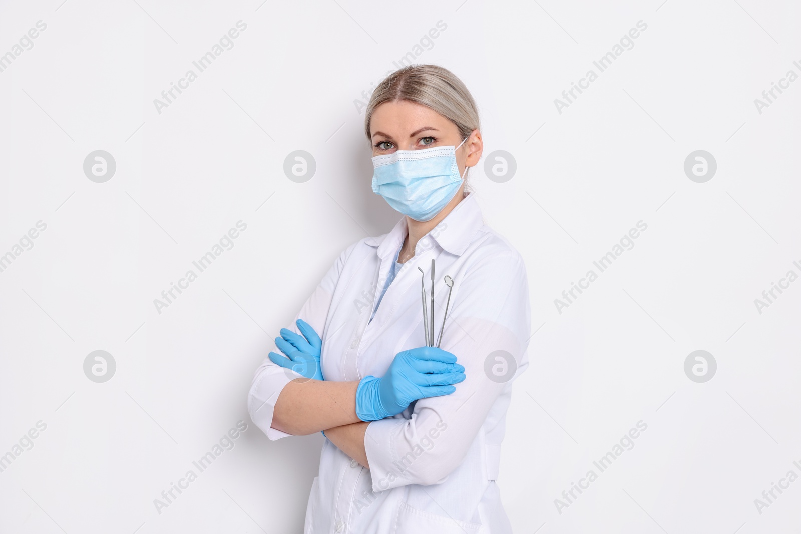 Photo of Professional dentist with tools on white background