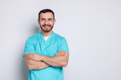 Portrait of professional dentist on light background. Space for text