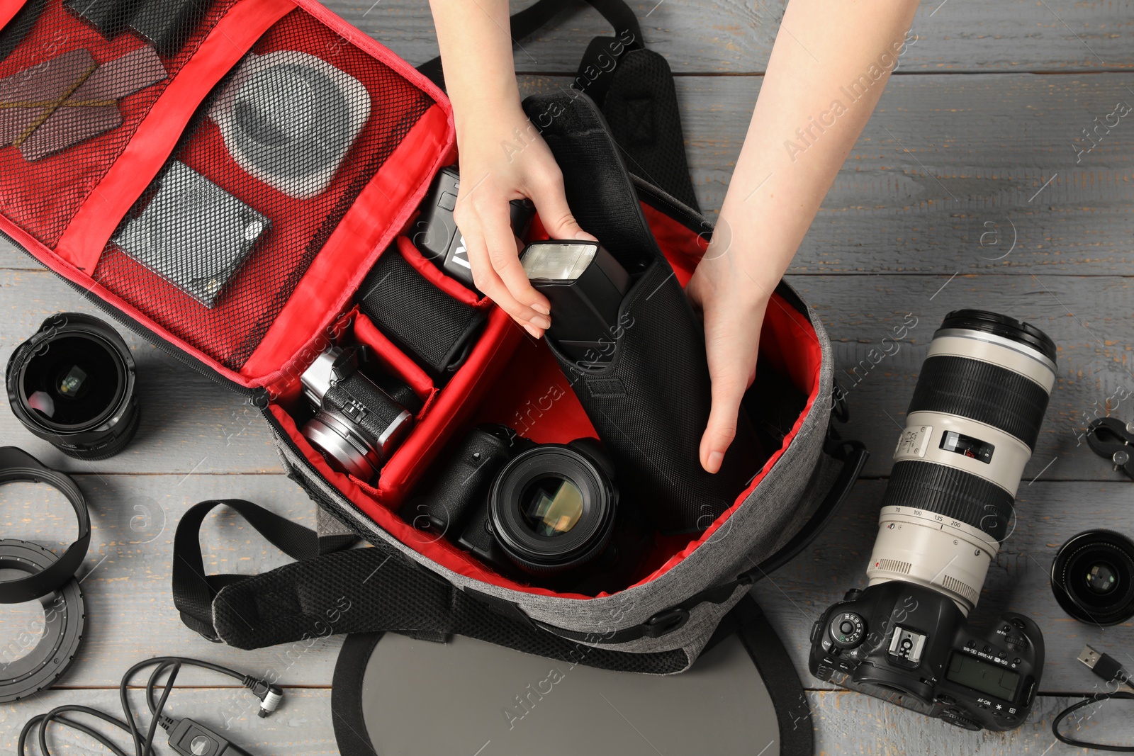Photographer with professional equipment and backpack at light wooden table, top view Photo of Photographer with professional equipment and backpack at light wooden table, top view