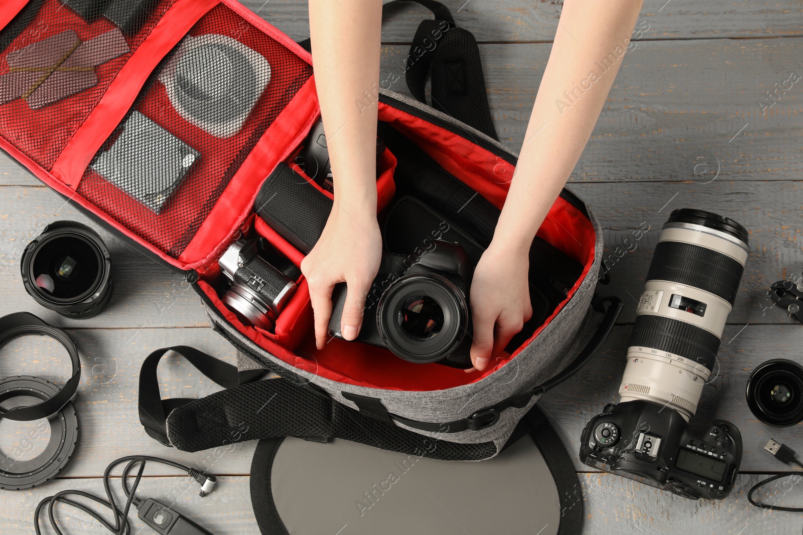 Photographer with professional equipment and backpack at light wooden table, top view Photo of Photographer with professional equipment and backpack at light wooden table, top view