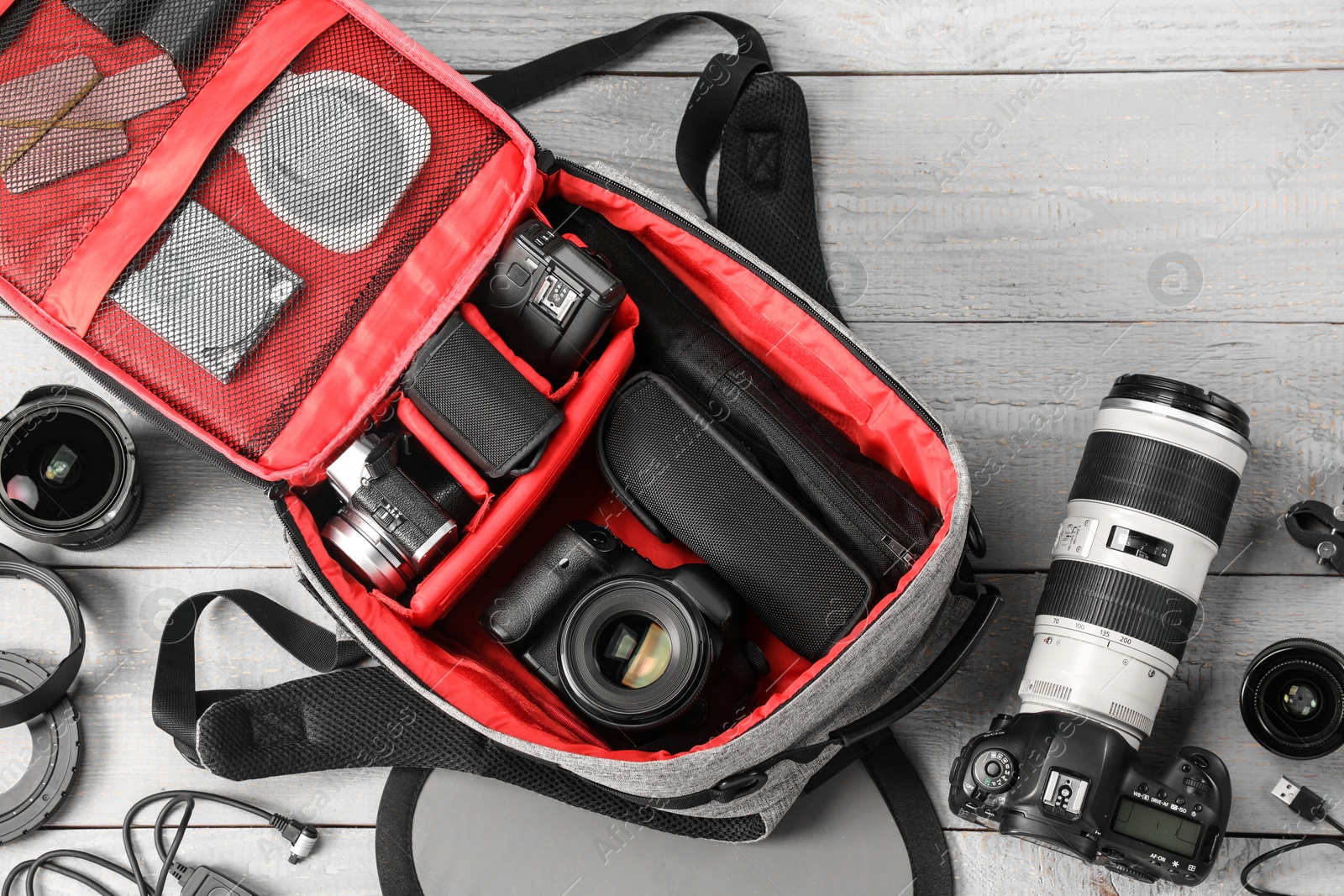 Professional photographer's equipment and backpack on light wooden table, flat lay Photo of Professional photographer's equipment and backpack on light wooden table, flat lay